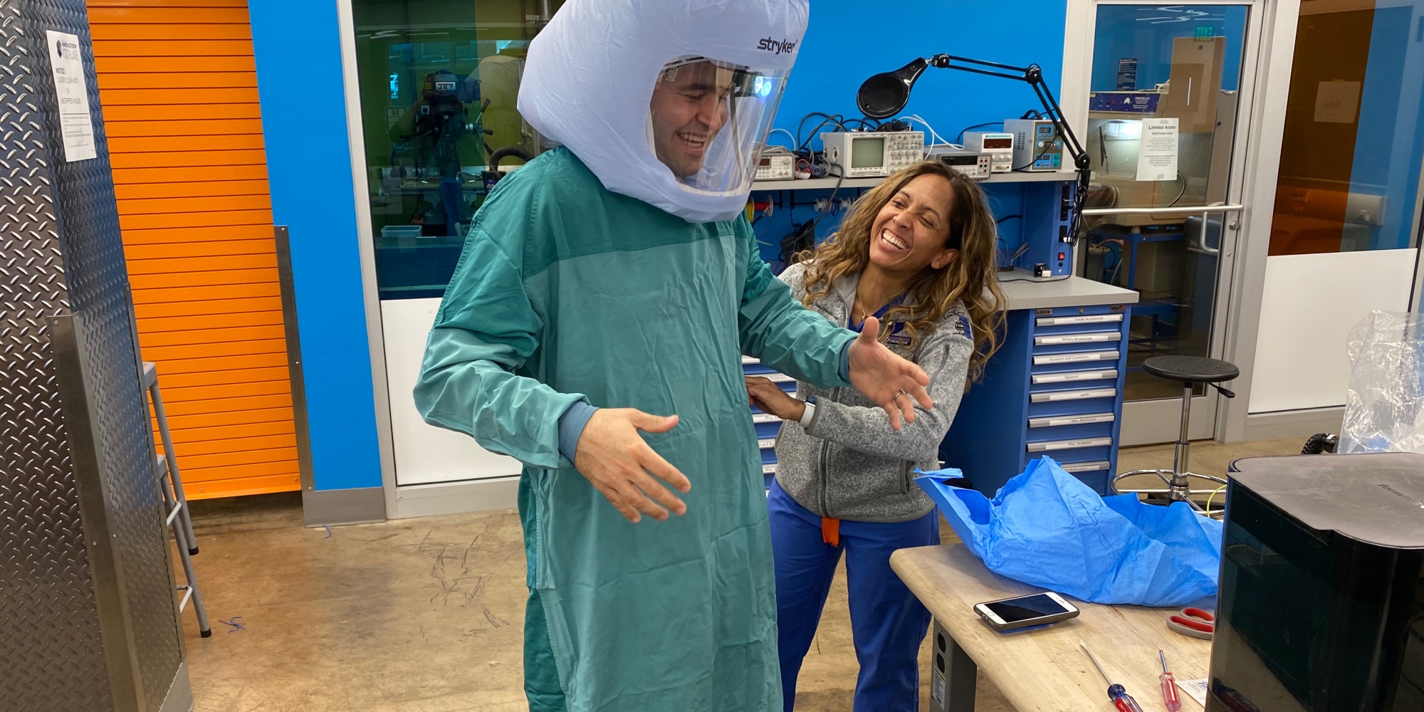 Eric Richardson and Dr. Melissa Erickson test the prototype of the PAPR hood