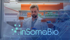 man in white lab coat working at a table with inSomaBio logo overtop