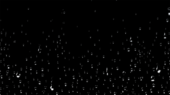 Water droplets cascading down a black background