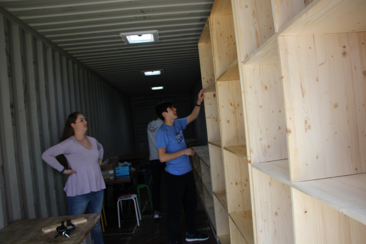 The students secure the placement of the new bookshelf