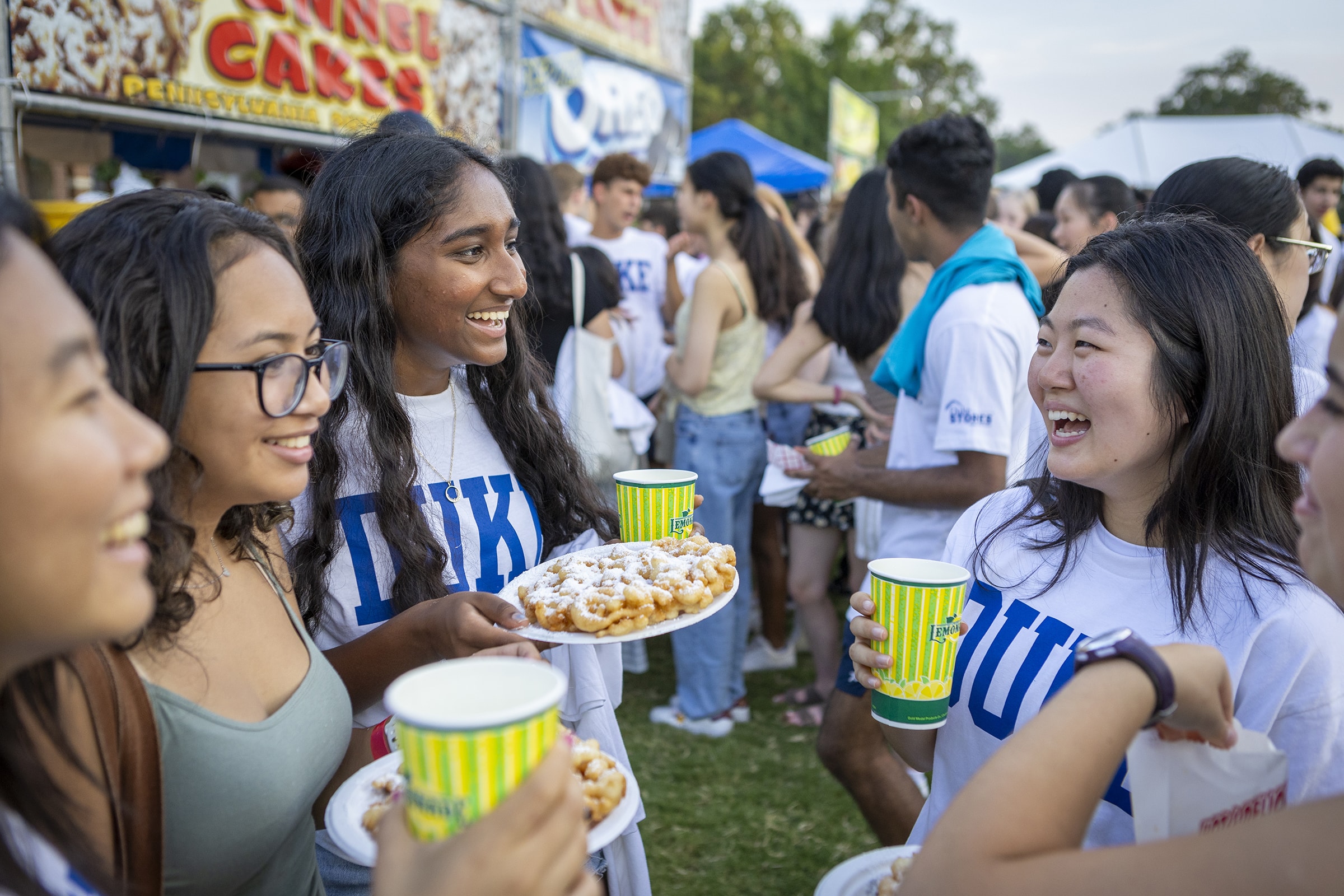 People laugh and eat at a carnival