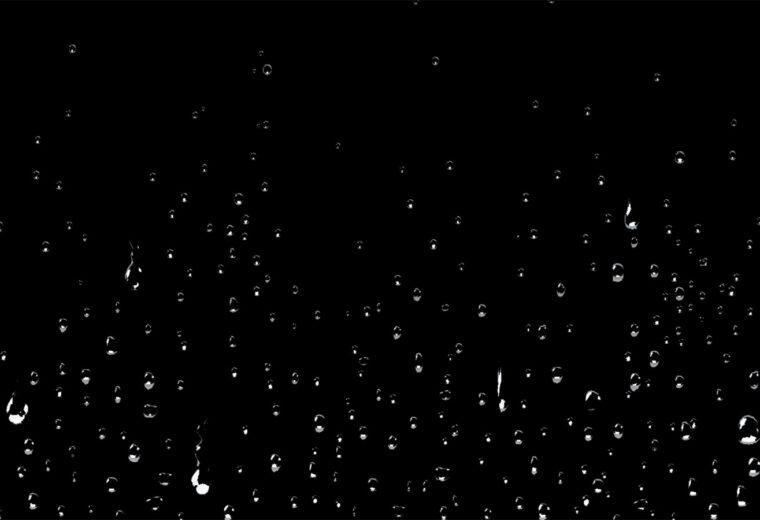 Water droplets cascading down a black background