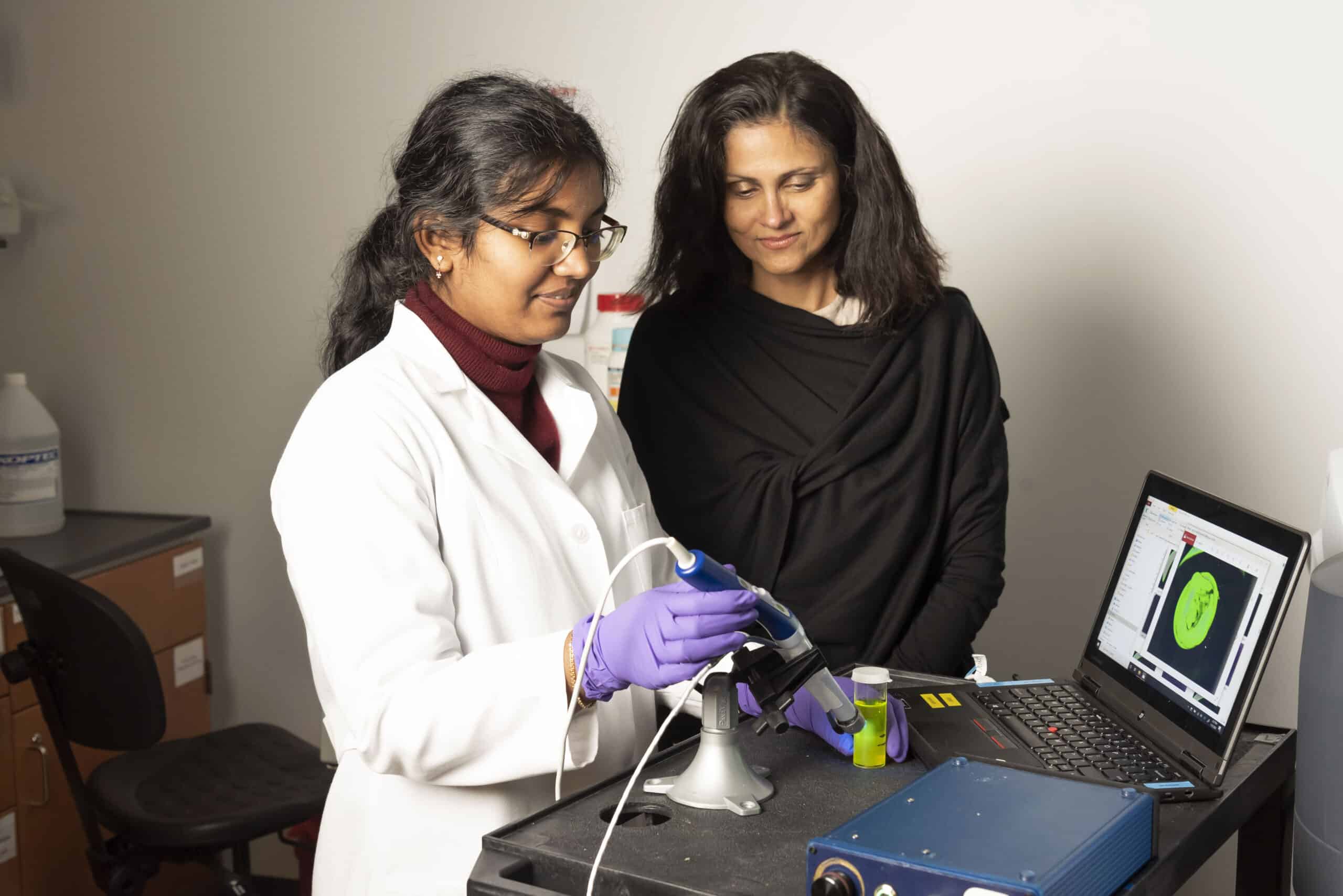 Nimmi Ramanujam and Enakshi Sunassee work on the Pocket Colposcope