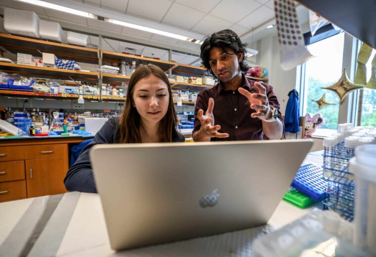 Pranam Chatterjee speaks with a student in his lab