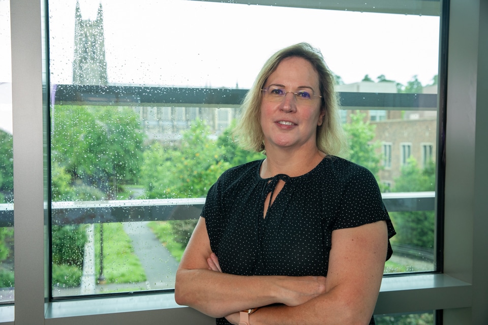 Sharon Gerecht in front of window overlooking Duke Chapel