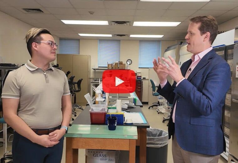 Two professors standing in a bioengineering lab talking to each other.