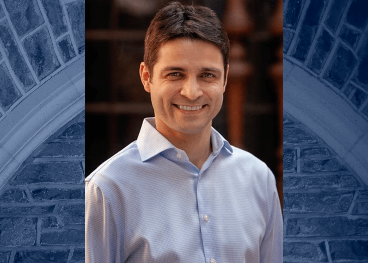 Mikhail Shapiro's headshot against a blue toned photo fo the Duke brick